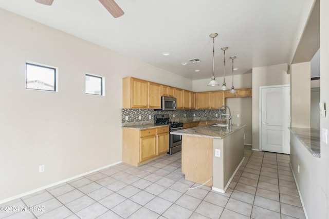 kitchen with backsplash, a center island with sink, ceiling fan, decorative light fixtures, and stainless steel appliances
