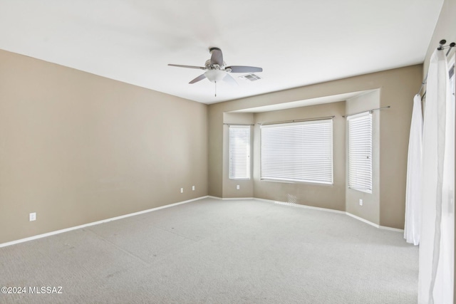 spare room with light colored carpet and ceiling fan