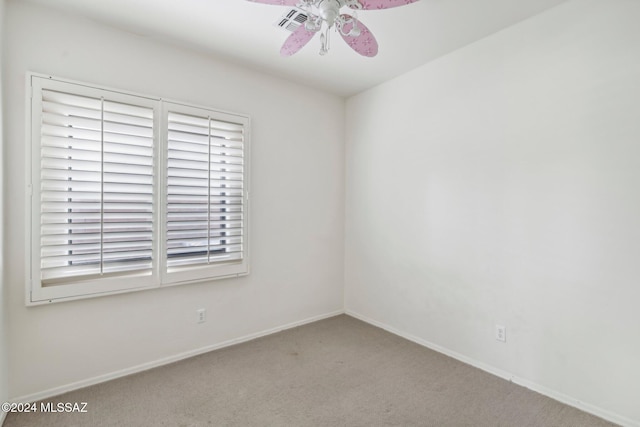 carpeted spare room with ceiling fan