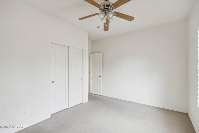 unfurnished bedroom featuring light carpet, a closet, and ceiling fan
