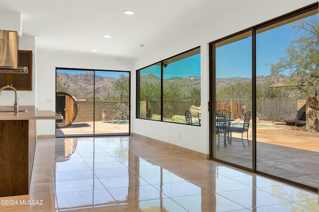 doorway to outside with a mountain view, light tile patterned floors, and sink