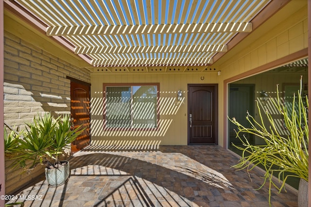 property entrance with a pergola