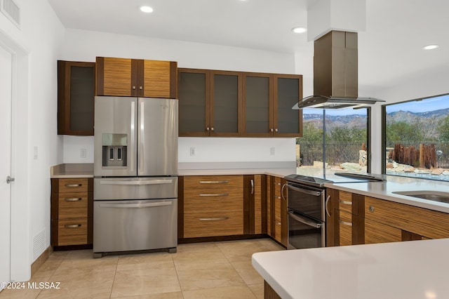 kitchen with island range hood, light tile patterned floors, and stainless steel appliances