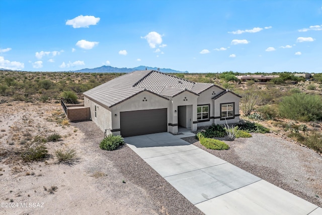 view of front of property featuring a garage and a mountain view