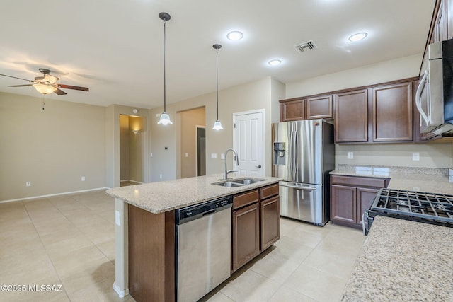 kitchen featuring a kitchen island with sink, sink, ceiling fan, decorative light fixtures, and stainless steel appliances