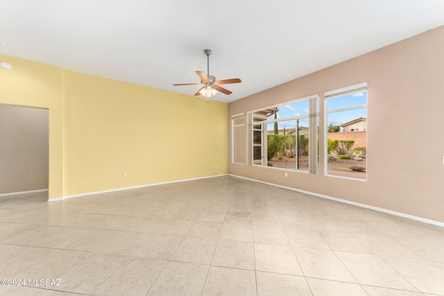 tiled spare room featuring ceiling fan