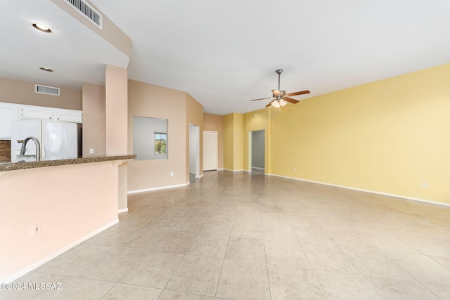 unfurnished living room with ceiling fan and light tile patterned floors