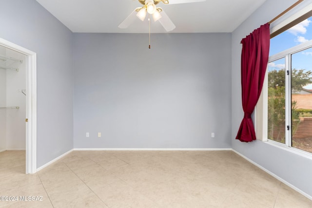 spare room featuring ceiling fan and a healthy amount of sunlight