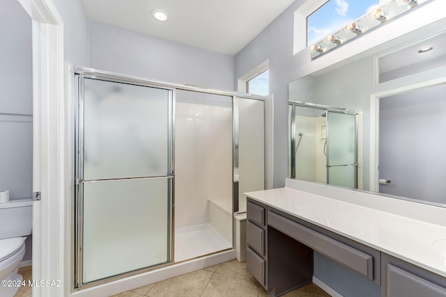 bathroom featuring tile patterned floors, vanity, toilet, and walk in shower