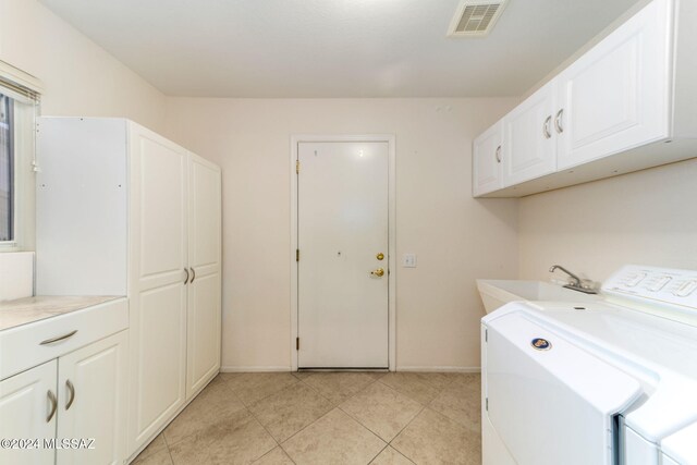 laundry area featuring cabinets, sink, light tile patterned flooring, and washer and dryer