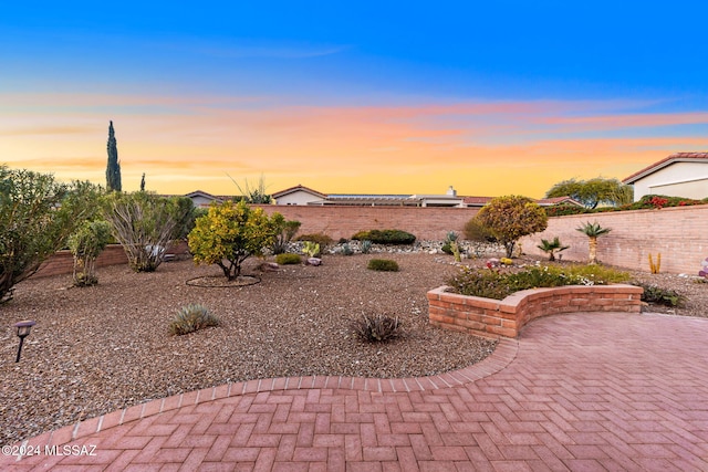 yard at dusk featuring a patio area