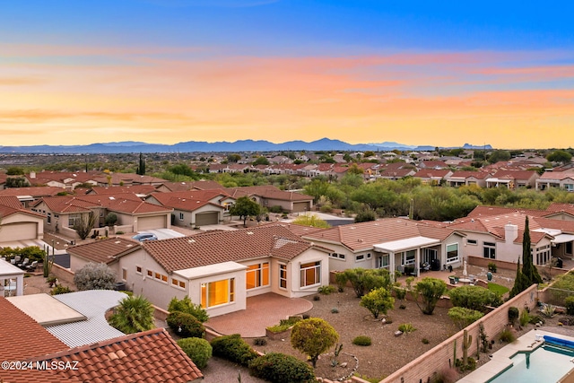 aerial view at dusk featuring a mountain view