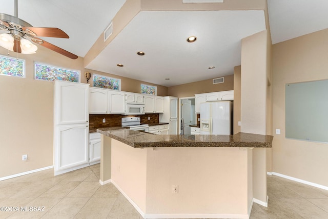 kitchen with white cabinets, light tile patterned floors, white appliances, and tasteful backsplash