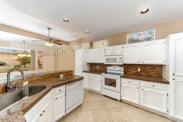 kitchen with decorative backsplash, white cabinetry, sink, and white appliances