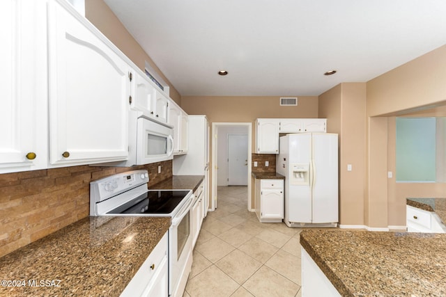 kitchen featuring backsplash, white appliances, light tile patterned floors, dark stone countertops, and white cabinets