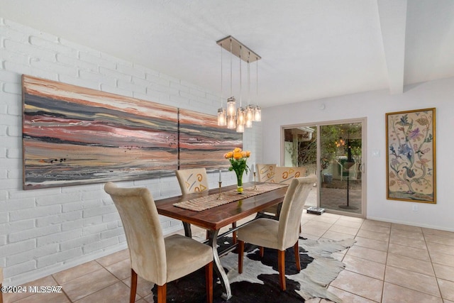 tiled dining space with beamed ceiling and brick wall