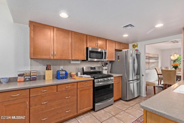 kitchen with decorative backsplash, stainless steel appliances, and light tile patterned floors