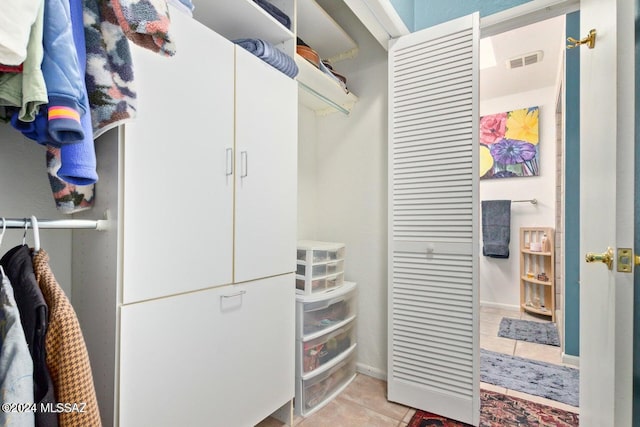 walk in closet with light tile patterned floors