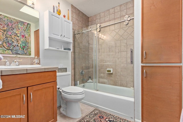 full bathroom with vanity, toilet, tile patterned floors, and bath / shower combo with glass door