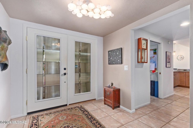 entryway with french doors, a textured ceiling, and light tile patterned floors