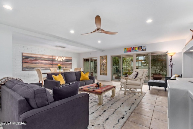 tiled living room with ceiling fan with notable chandelier