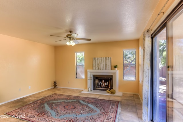 10081 N Pitchingwedge Ln, Tucson, AZ 85737 - unfurnished living room featuring plenty of natural light, ceiling fan, a fireplace with raised hearth, and light tile patterned floors