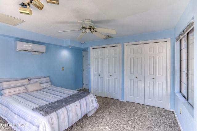 bedroom with light colored carpet, multiple closets, an AC wall unit, and ceiling fan