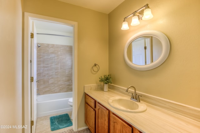 full bathroom with tiled shower / bath, vanity, and toilet