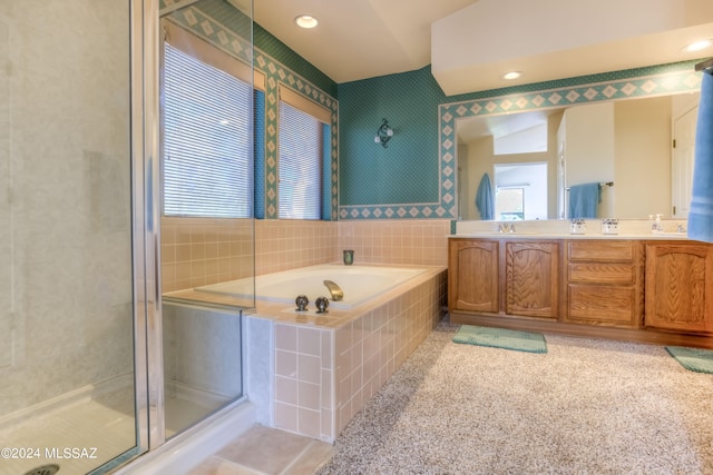 bathroom with vanity, shower with separate bathtub, vaulted ceiling, and a wealth of natural light