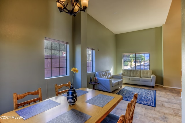 dining area featuring a notable chandelier and high vaulted ceiling