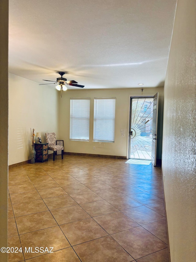 unfurnished room featuring light tile patterned flooring and ceiling fan