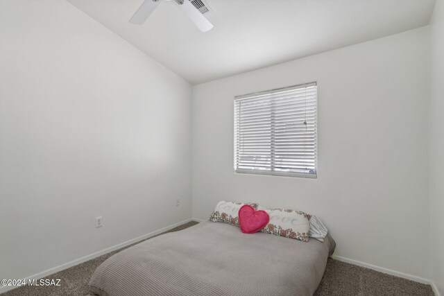 carpeted bedroom with ceiling fan and vaulted ceiling