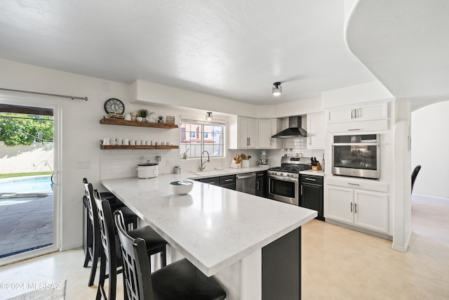 kitchen featuring kitchen peninsula, stainless steel appliances, and plenty of natural light