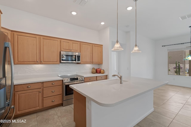 kitchen with appliances with stainless steel finishes, a sink, backsplash, light tile patterned flooring, and light countertops