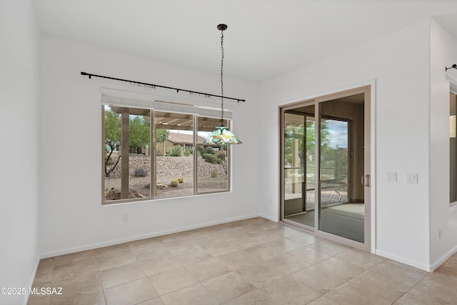 unfurnished dining area with baseboards and light tile patterned floors