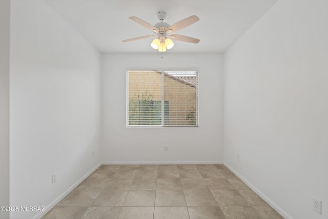 empty room featuring ceiling fan and baseboards