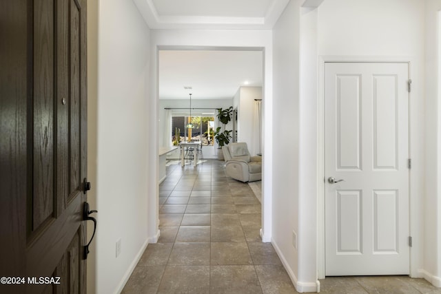 entryway featuring baseboards and dark tile patterned flooring