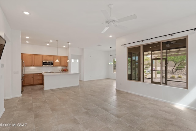unfurnished living room with ceiling fan, baseboards, and recessed lighting