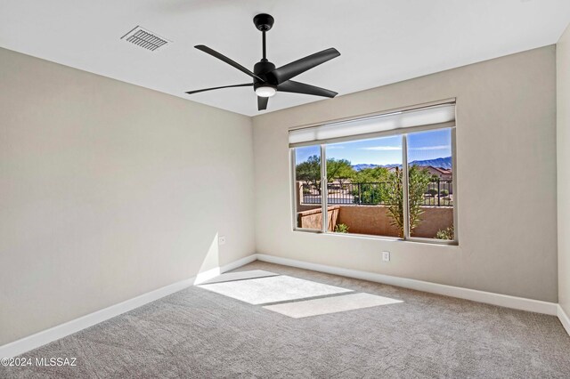 carpeted spare room with ceiling fan