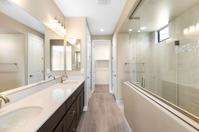 bathroom with vanity, wood-type flooring, and a shower with door