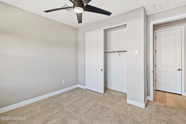 unfurnished bedroom with a closet, ceiling fan, and light carpet