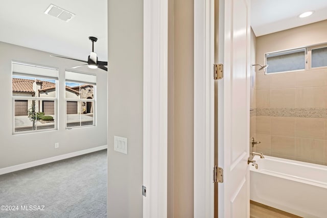 bathroom with a washtub and ceiling fan