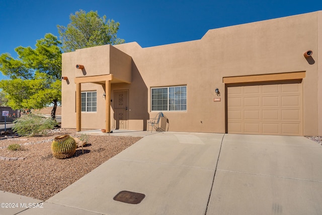 pueblo revival-style home featuring a garage