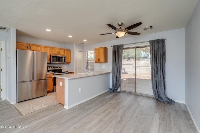 kitchen featuring kitchen peninsula, sink, light wood-type flooring, appliances with stainless steel finishes, and ceiling fan