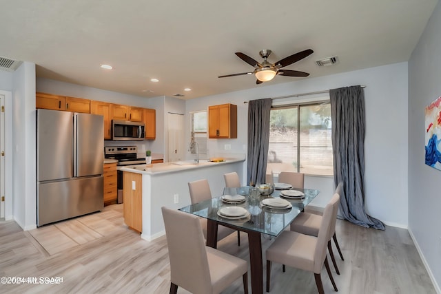 dining space with light hardwood / wood-style floors, sink, and ceiling fan