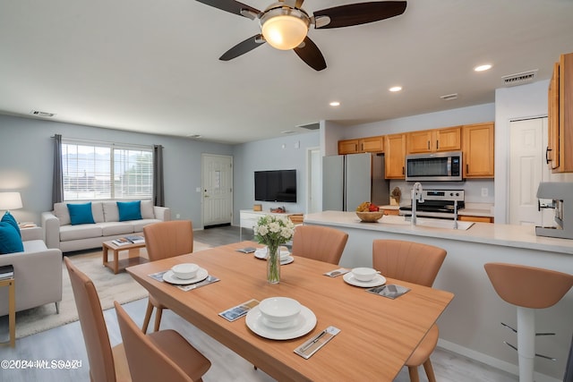 dining area with ceiling fan and light hardwood / wood-style floors