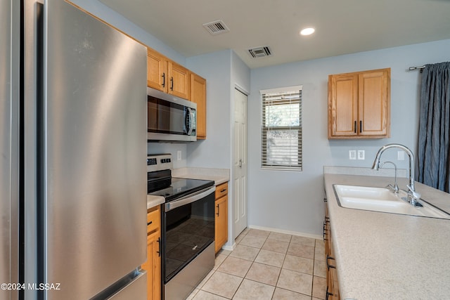 kitchen featuring light tile patterned flooring, stainless steel appliances, and sink