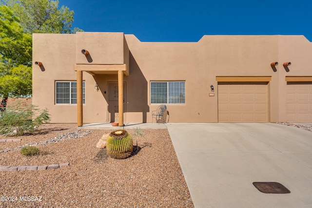 pueblo-style home featuring a garage