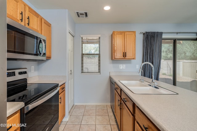 kitchen with sink, stainless steel appliances, and light tile patterned floors