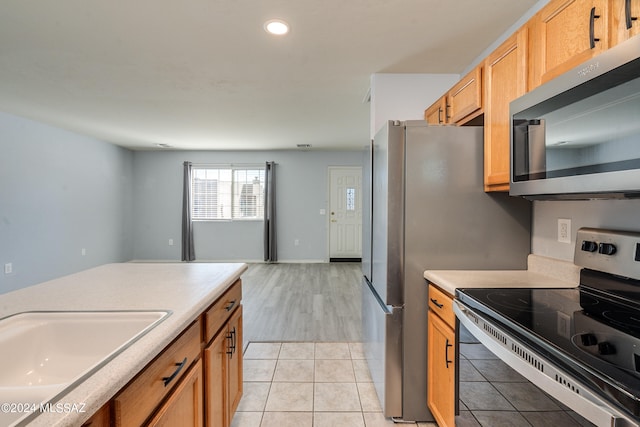 kitchen featuring stainless steel appliances, sink, and light tile patterned floors